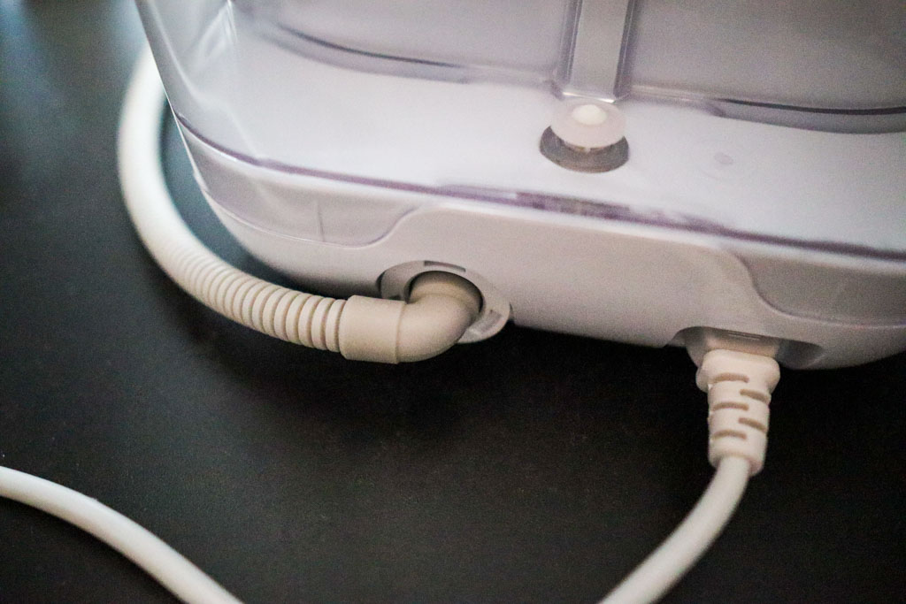 Close-up of the rubber connector on the Momcozy KleanPal Pro drainage hose that snaps onto the appliance to prevent leaks