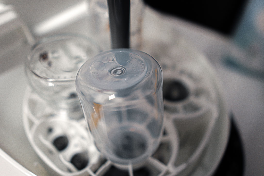 A photo of water droplets pooling on the underside of an inverted baby bottle inside the Baby Brezza Bottle Washer Pro.