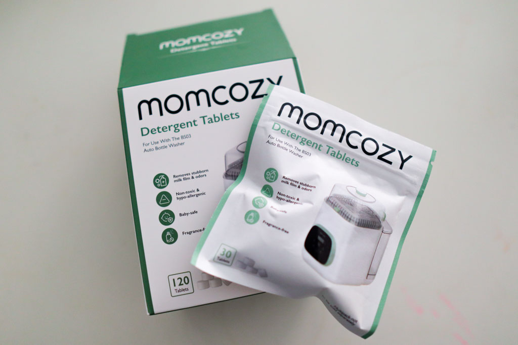 Two boxes of Momcozy proprietary detergent tablets for the KleanPal Pro, showing the 120-count and 30-count packaging.