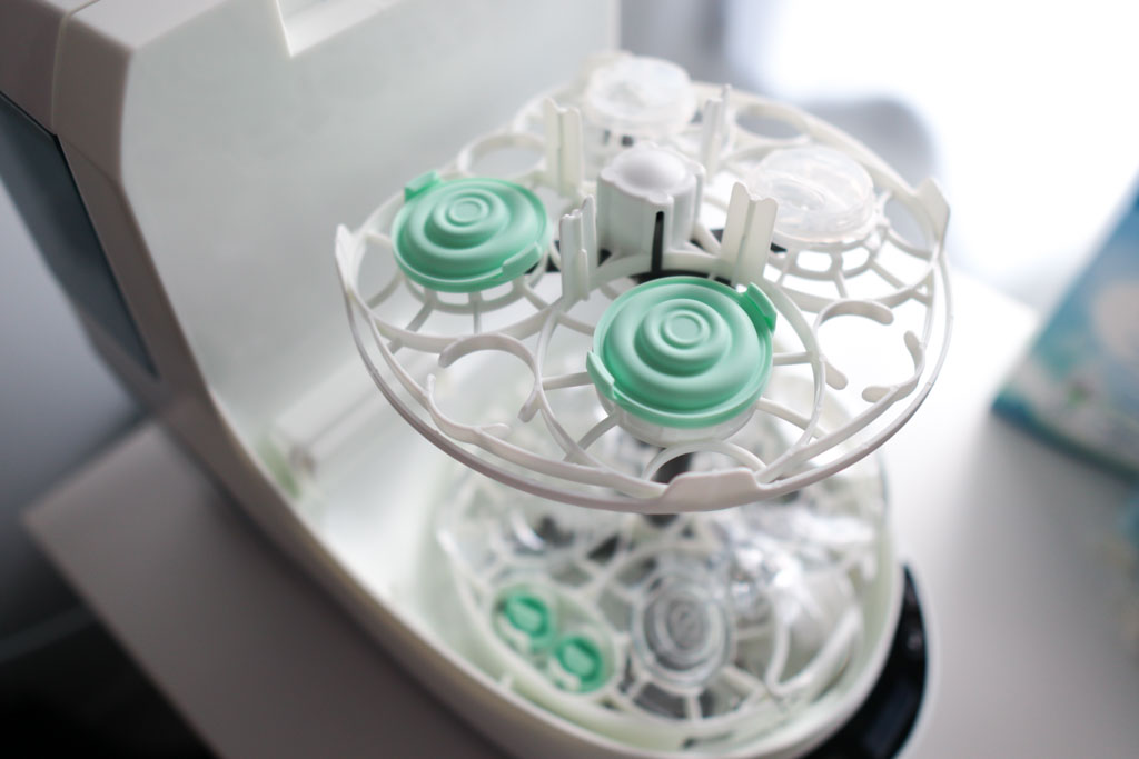 Elvie breast pump parts arranged on the top and bottom racks of the Baby Brezza Bottle Washer Pro, ready for a wash cycle.