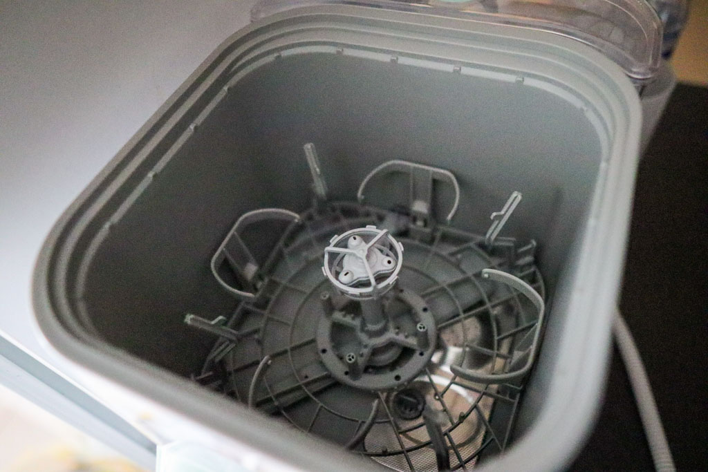 A photo of the Momcozy KleanPal Pro with the lid removed, showcasing the bottle rack in the interior of the appliance.
