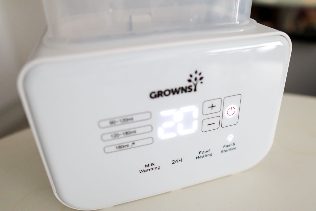 Close-up of the Grownsy 8-in-1 Bottle Warmer's touch panel showing mode buttons, temperature display, and timer controls.
