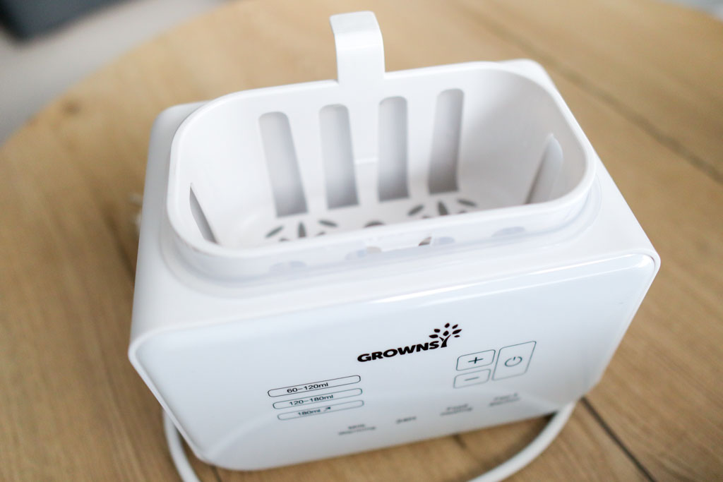 The Grownsy 8-in-1 Bottle Warmer in compact storage mode with the lid flipped and anti-scald basket nested inside.